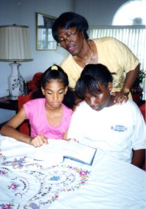 Grandmother and two granddaughters looking at Bible