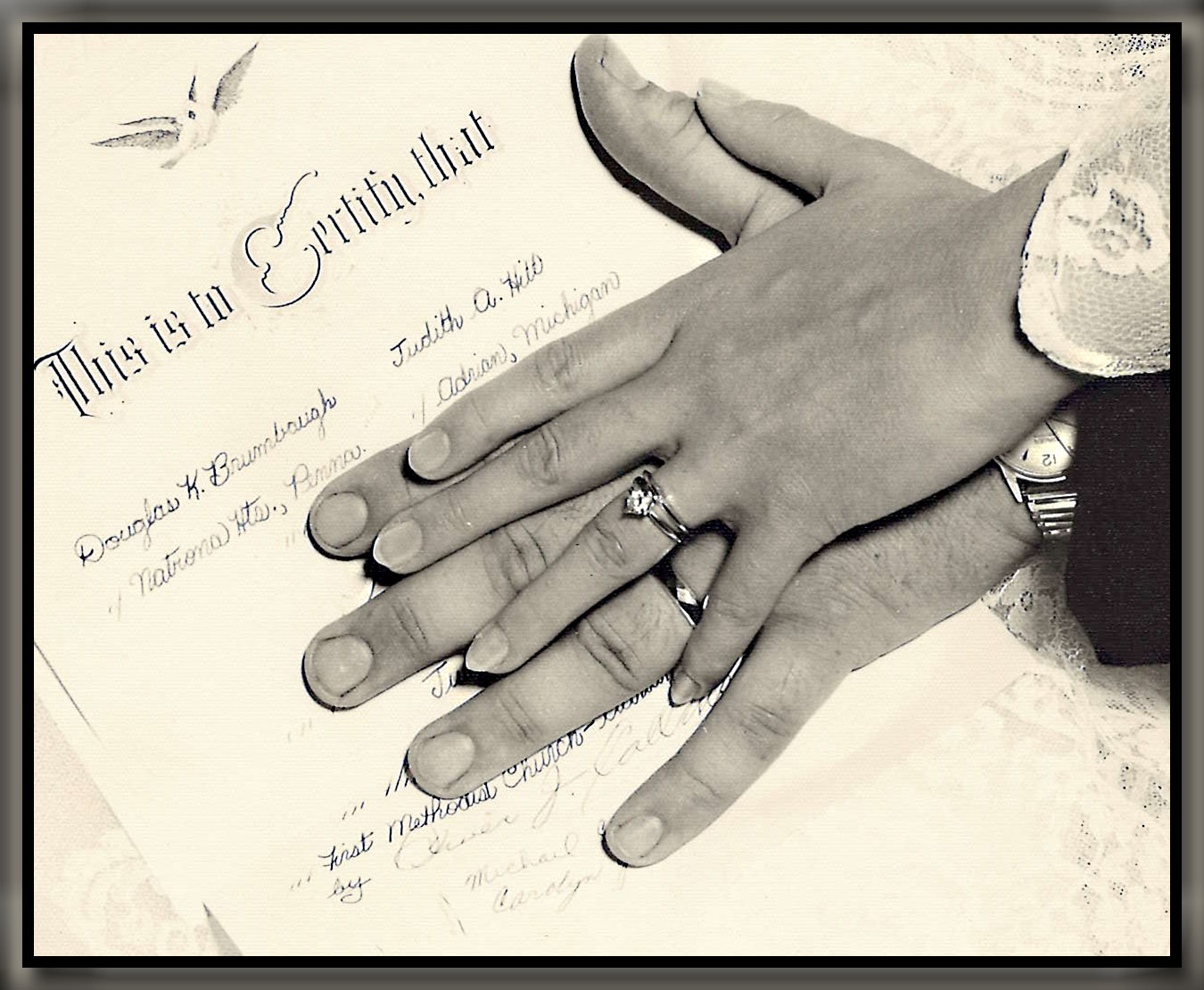 marriage license with husband and wife's hands over top